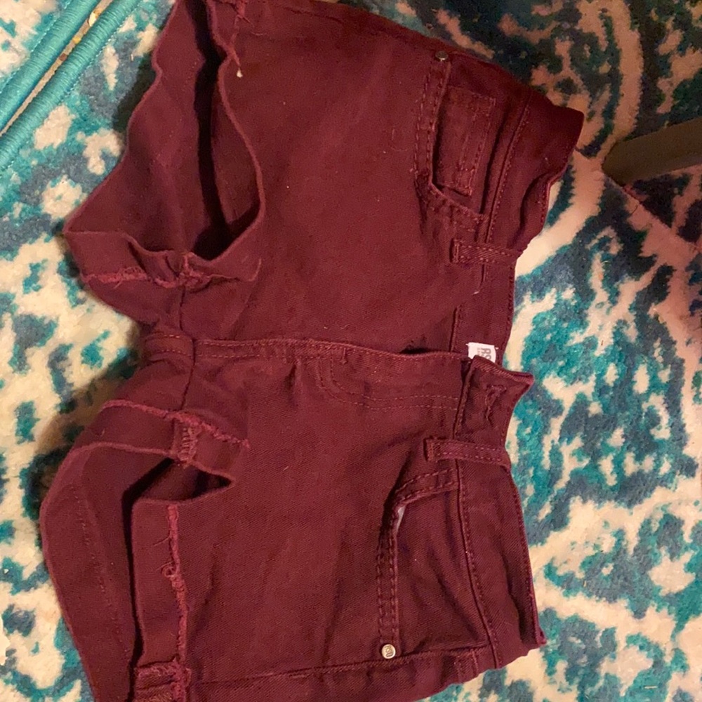 A dark magenta, button & zipper with four pockets